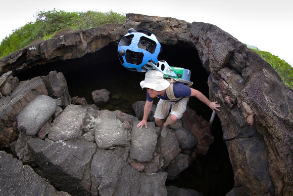 Daniel Orellana of the Charles Darwin Foundation climbsout of a lava tunnel where he was collecting imagery. Thedramatic lava landscapes found on Isabela island tell thestory of the formation of the G